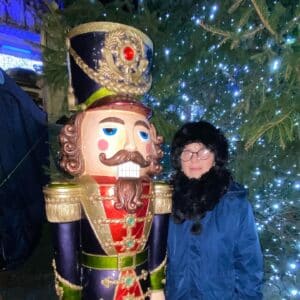 Sylvia standing next to a giant nutcracker figure at Belfast Christmas Market