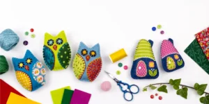 Colourful felt owl and house ornaments with buttons, scissors and threads