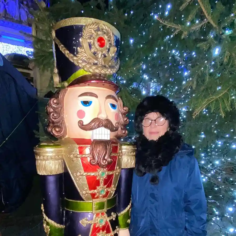 Sylvia standing with a giant nutcracker figure at Belfast Christmas market