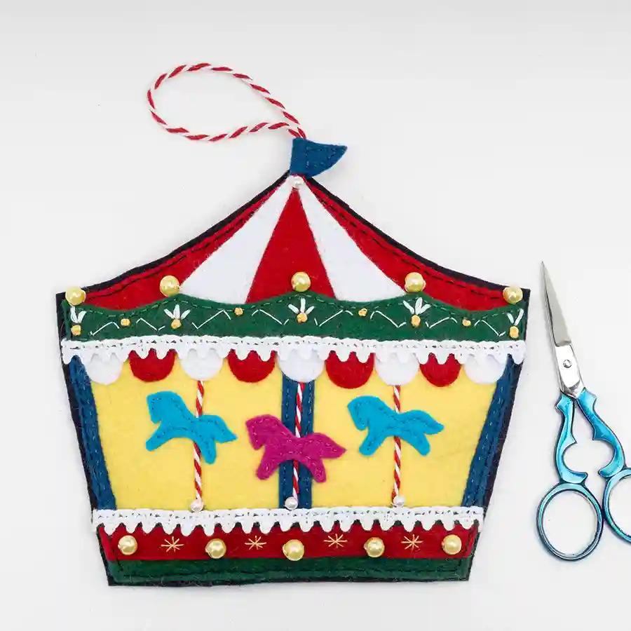 The finished Carousel felt ornament with a small pair of scissors.