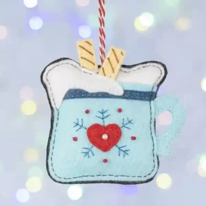 Hot chocolate mug felt ornament, light blue with red heart and snowflake design.