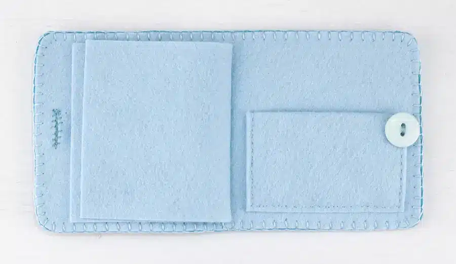 The inside of the needle book showing pages for needles and a small pocket at the back